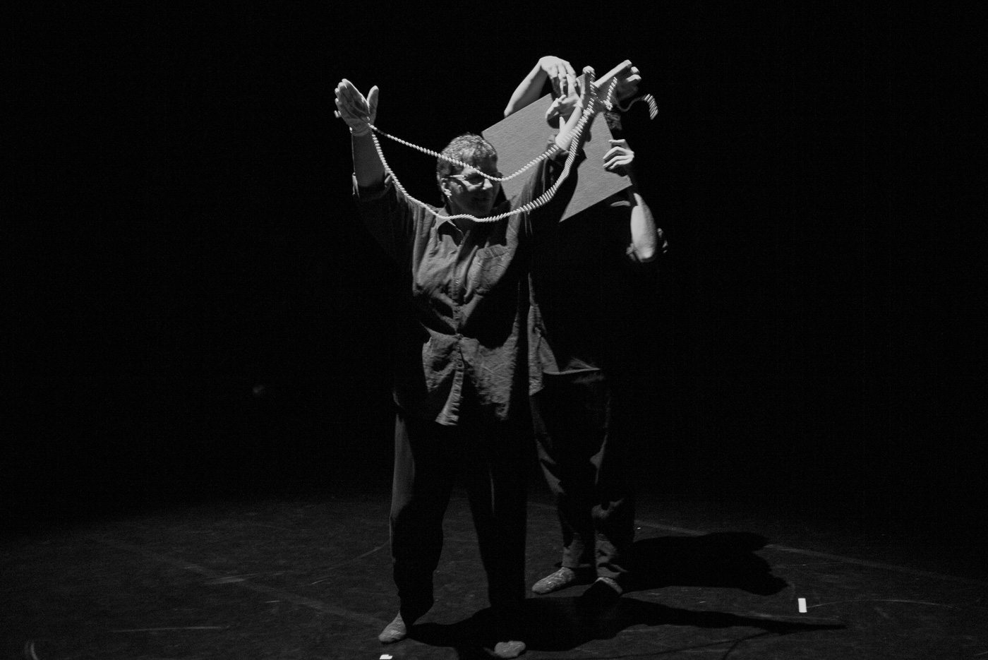 Black and white photo of Jackie dancing with beads in Adieu